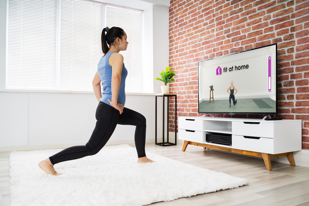 Woman doing a a lunge exercise at home
